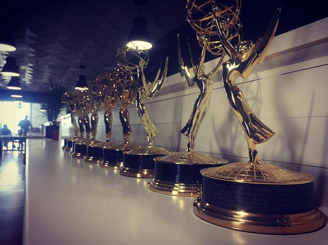 A row of Emmy Award statuettes on a shelf