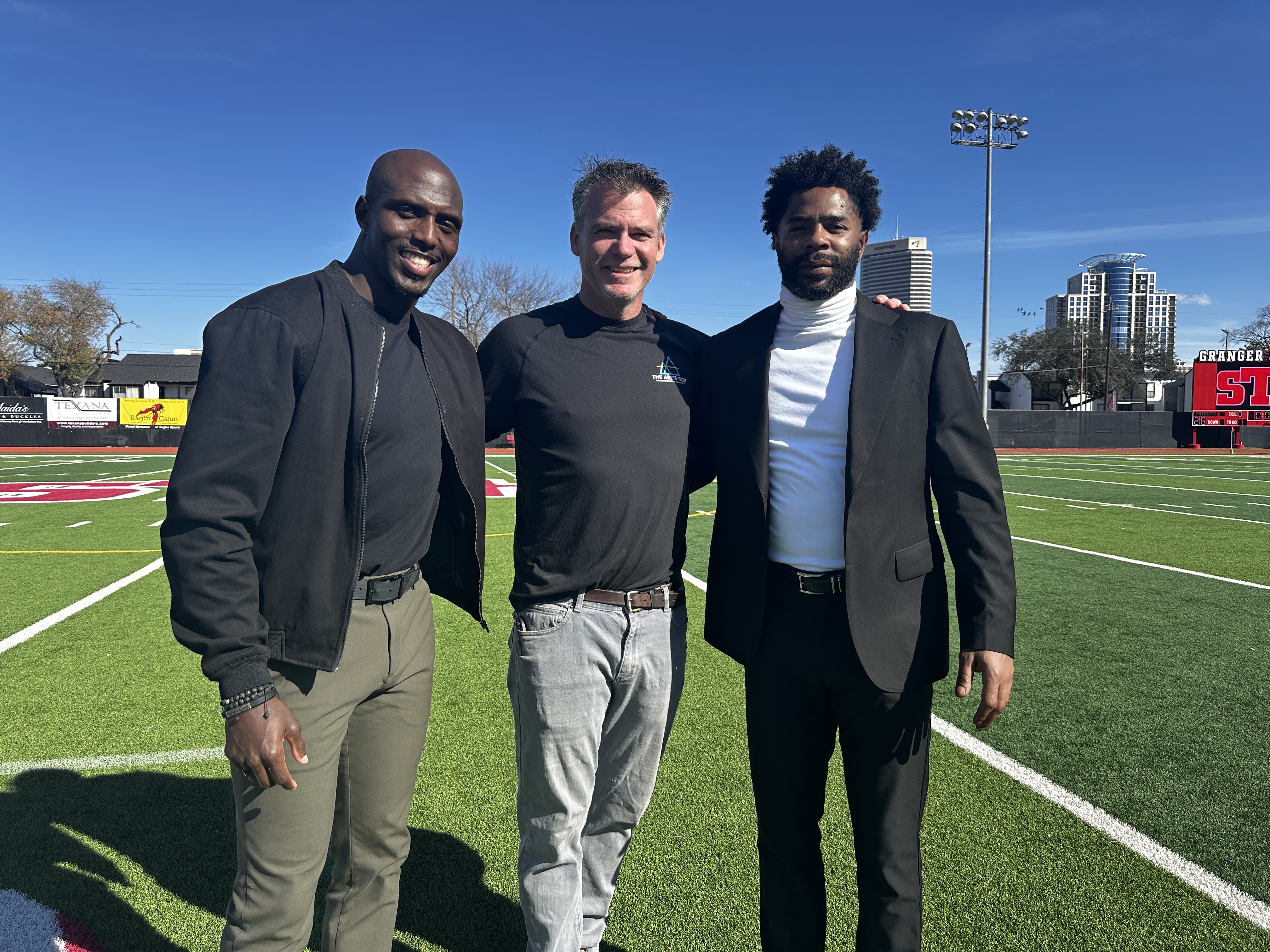 Eric on the field between Devin McCourty and Malcolm Butler during production of a Super Bowl feature for NBC